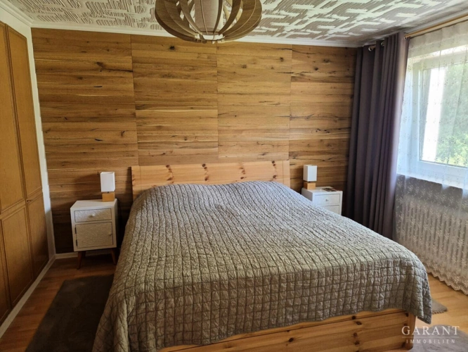 Schlafzimmer mit Echtholzrückwand und Einbauschran